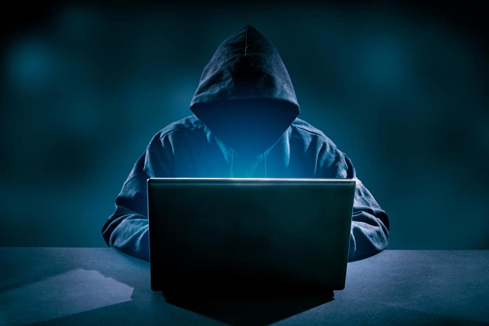a black hooded person using laptop